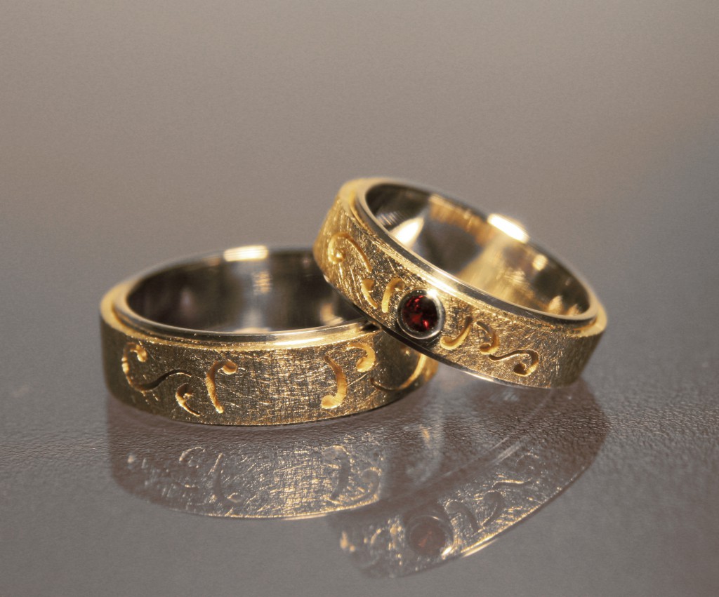 ornate silver and gold wedding bands with ruby