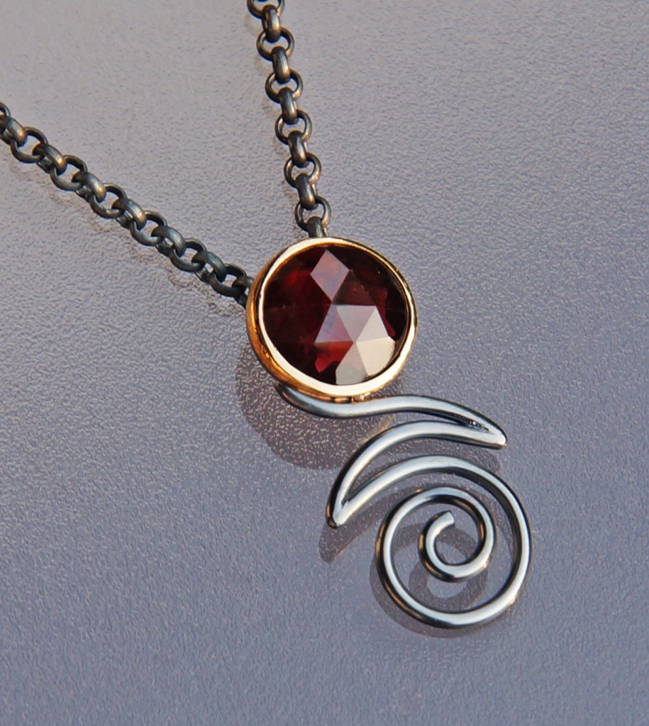 rose cut garnet in yellow gold setting with oxidized silver